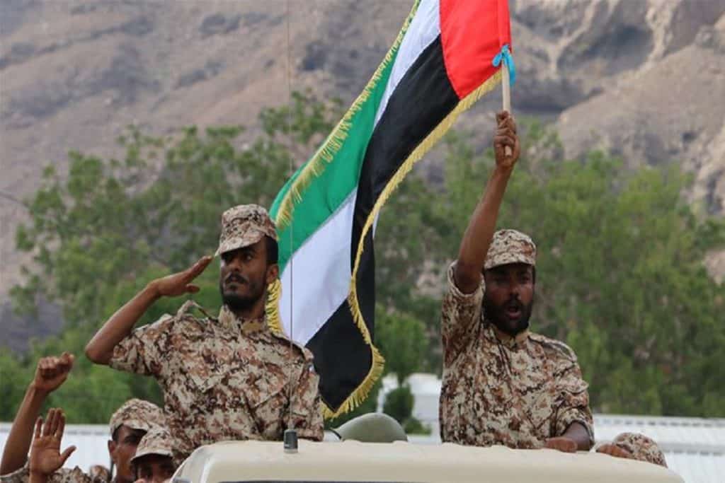 An Emirati forces-trained recruit of Yemen's army waves a UAE flag during combat exercises [