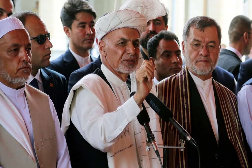 Afghanistan's President Ashraf Ghani, center, speaks after offering Eid al-Adha prayers at the presidential palace in Kabul, Afghanistan