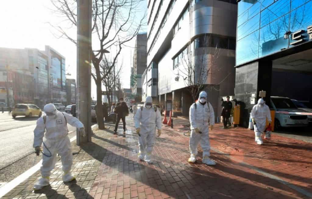 South Korean health officials wearing protective suit and spraying disinfectant in front of the Daegu branch of the Shincheonji Church of Jesus in the southeastern city of Daegu