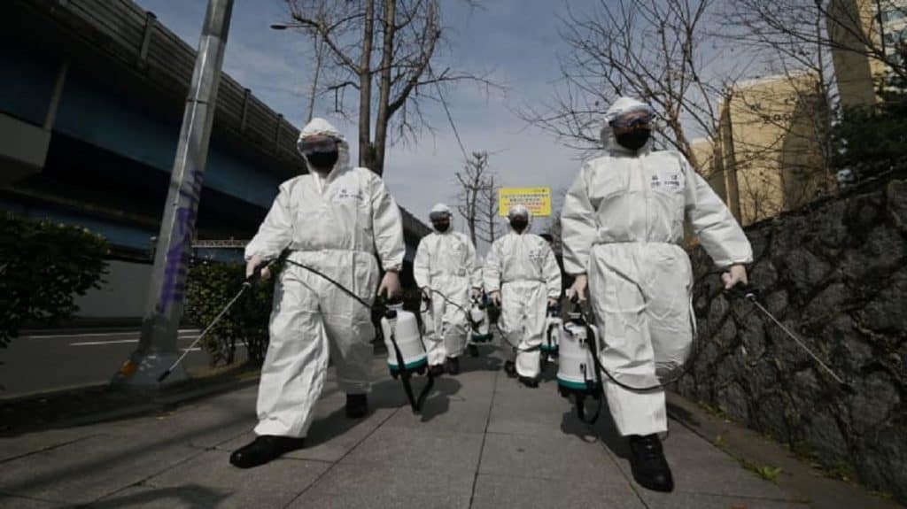 Soldiers wearing protective gear spray disinfectant on the street to help prevent the spread of the COVID-19 coronavirus, at a residential area in Seoul