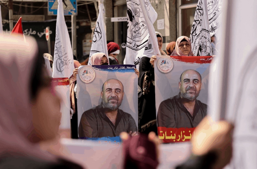 Posters depicting the late Nizar Banat at a demonstration in his memory in Gaza City